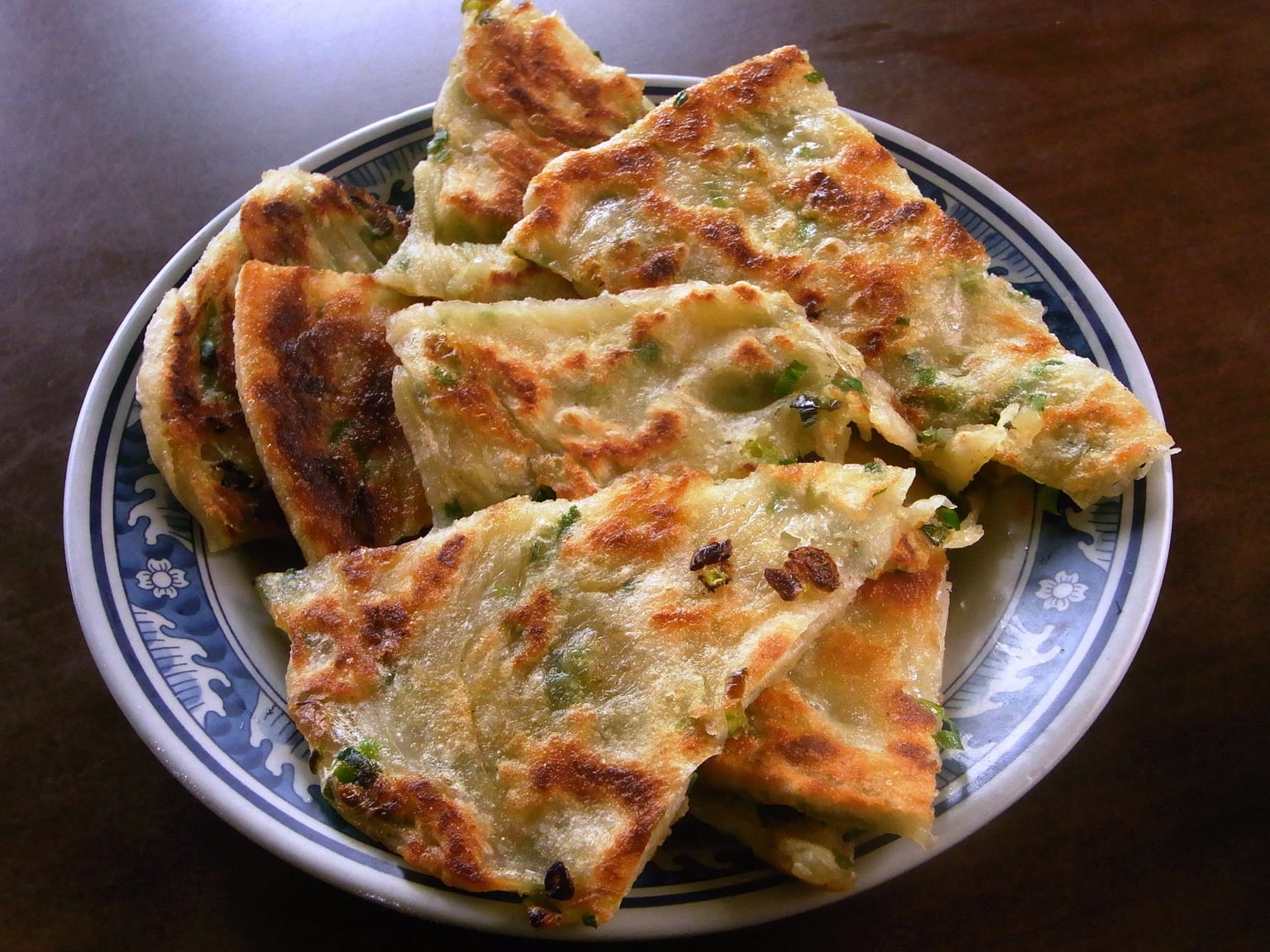 Buttery herb-and-onion layered pancakes served as a natural-light editorial food photograph