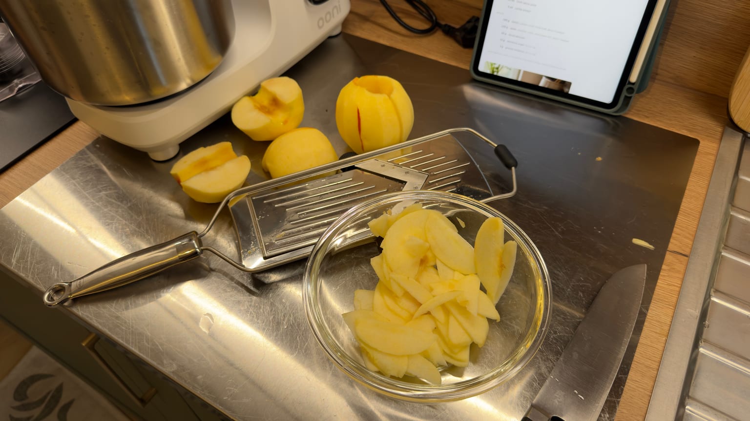 Apples sliced paper-thin in a glass bowl, ready to layer over the almonds and brown sugar